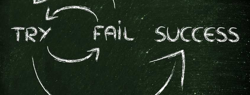 Blackboard with words "try", "fail", "success" and arrow symbols