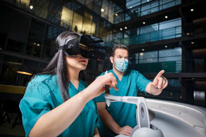 Two healthcare professionals, one using VR glasses