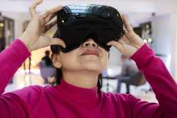 Woman in a pink shirt wearing VR glasses